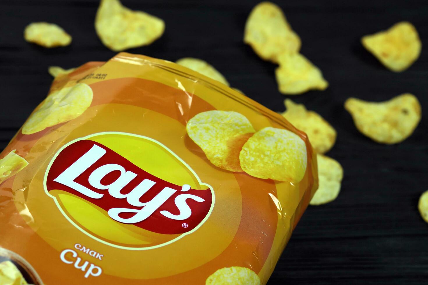 KHARKOV, UKRAINE - JANUARY 3, 2021 Lays potato chips with cheese flavour and original lays logo in middle of package. Worldwide famous brand of potato chips photo