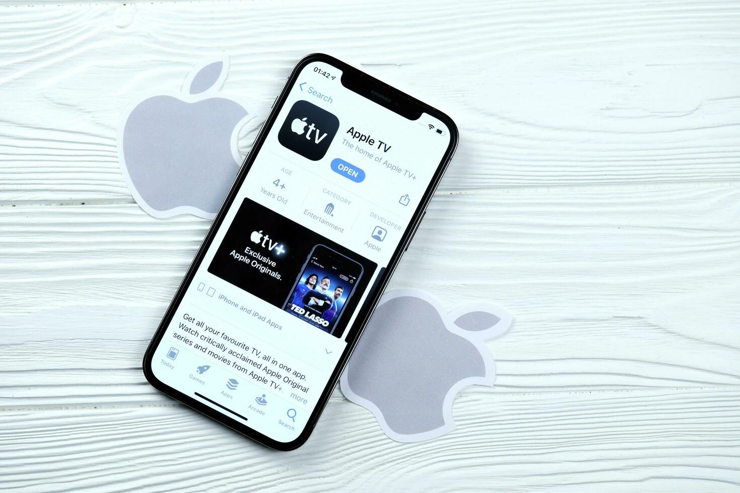 KHARKOV, UKRAINE - MARCH 5, 2021 Apple TV icon and application from App store on iPhone 12 pro display screen on white table photo