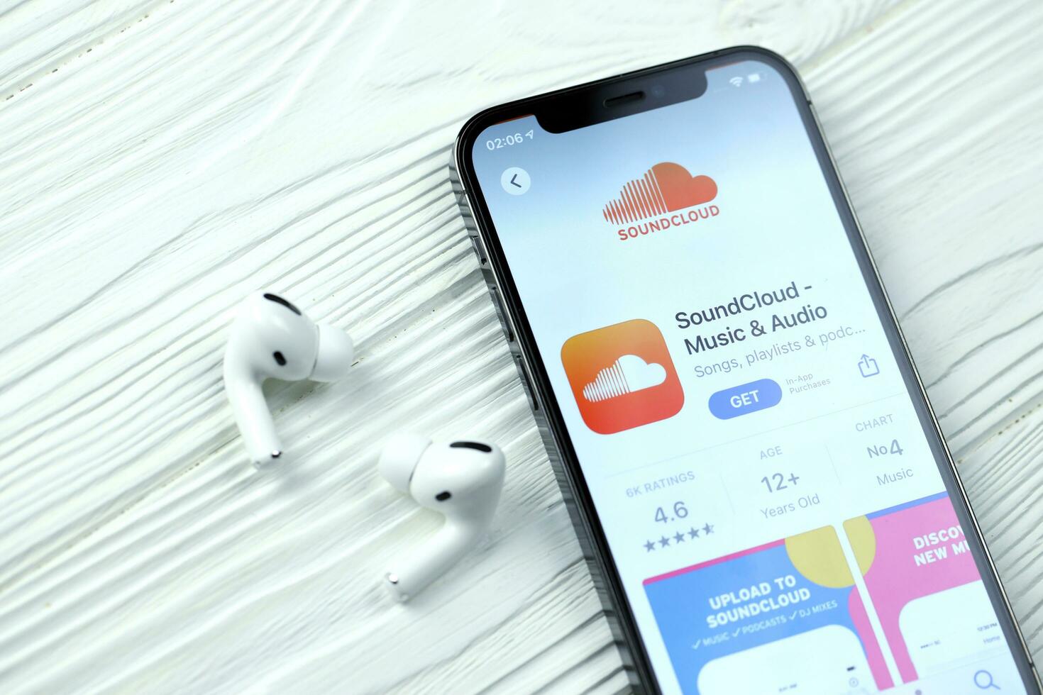 KHARKOV, UKRAINE - MARCH 5, 2021 Soundcloud icon and application from App store on iPhone 12 pro display screen with airpods pro on white table photo
