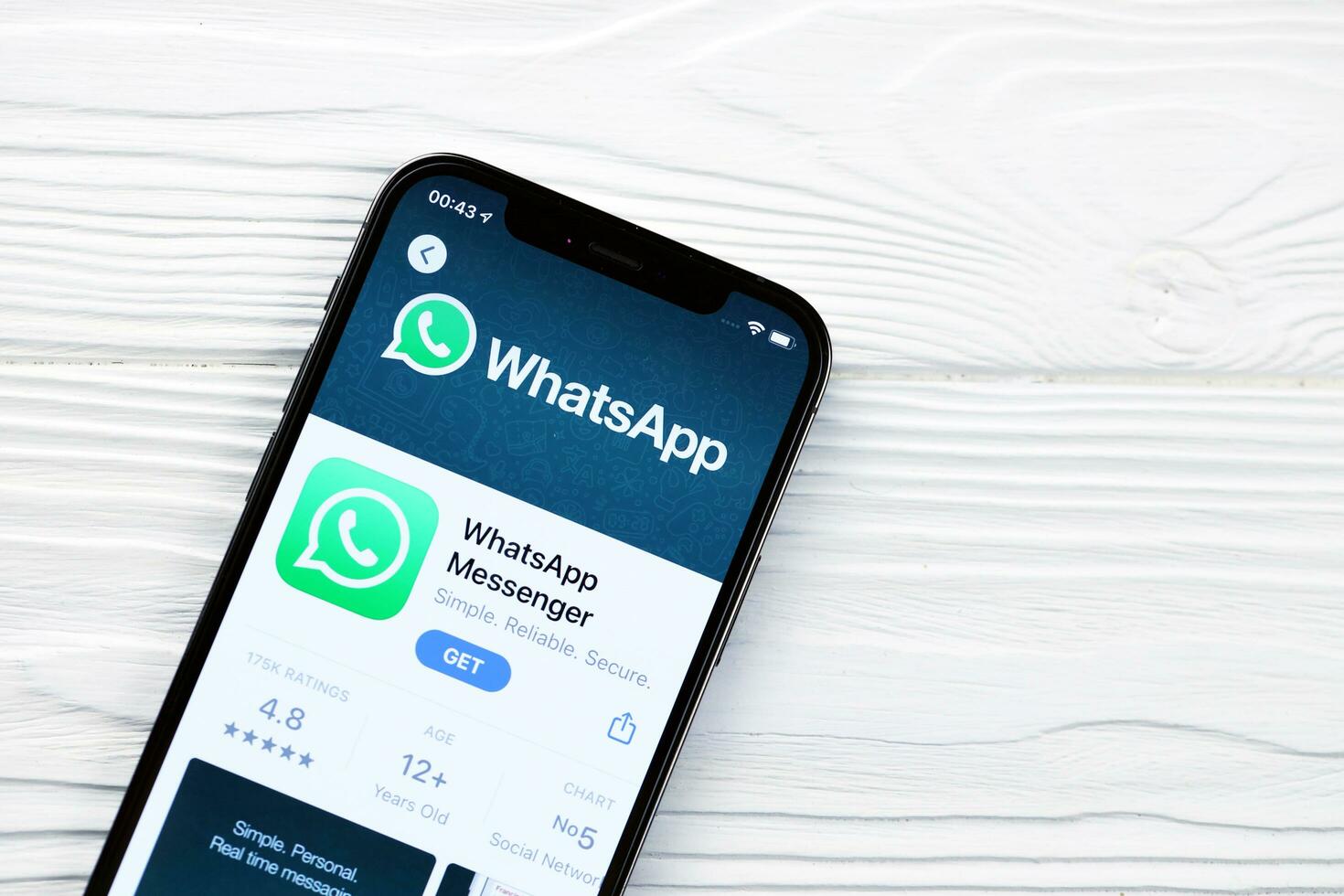 KHARKOV, UKRAINE - MARCH 5, 2021 Whatsapp icon and application from App store on iPhone 12 pro display screen on white table photo