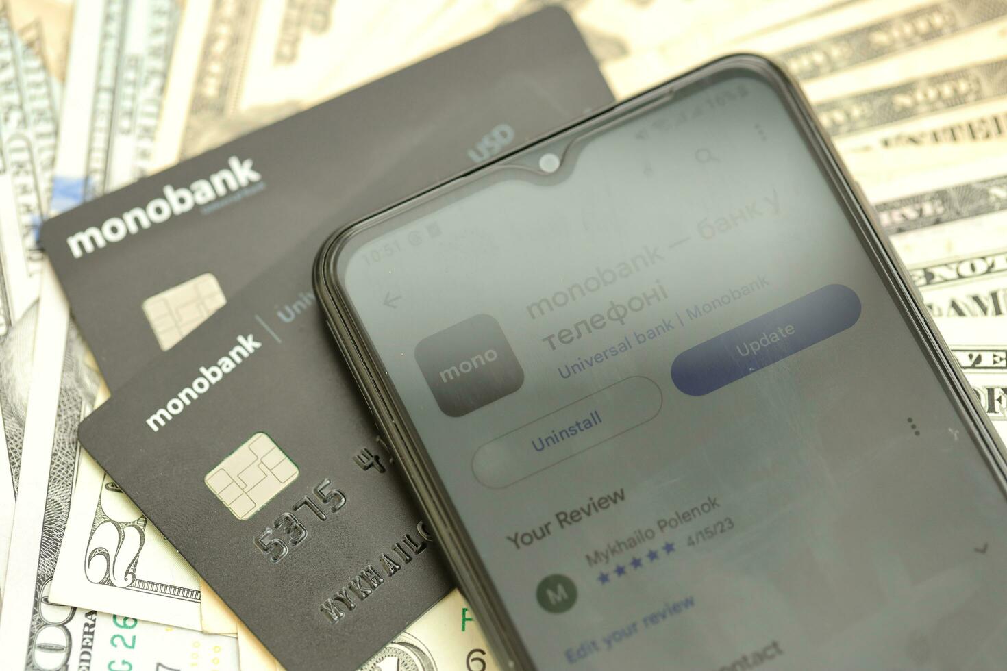 KYIV, UKRAINE - JULY 7, 2023 Monobank banking plastic cards with money on table photo