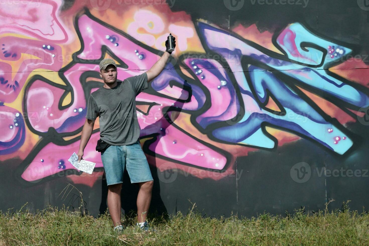 joven caucásico masculino pintada artista dibujo grande calle Arte pintura en azul y rosado tonos foto