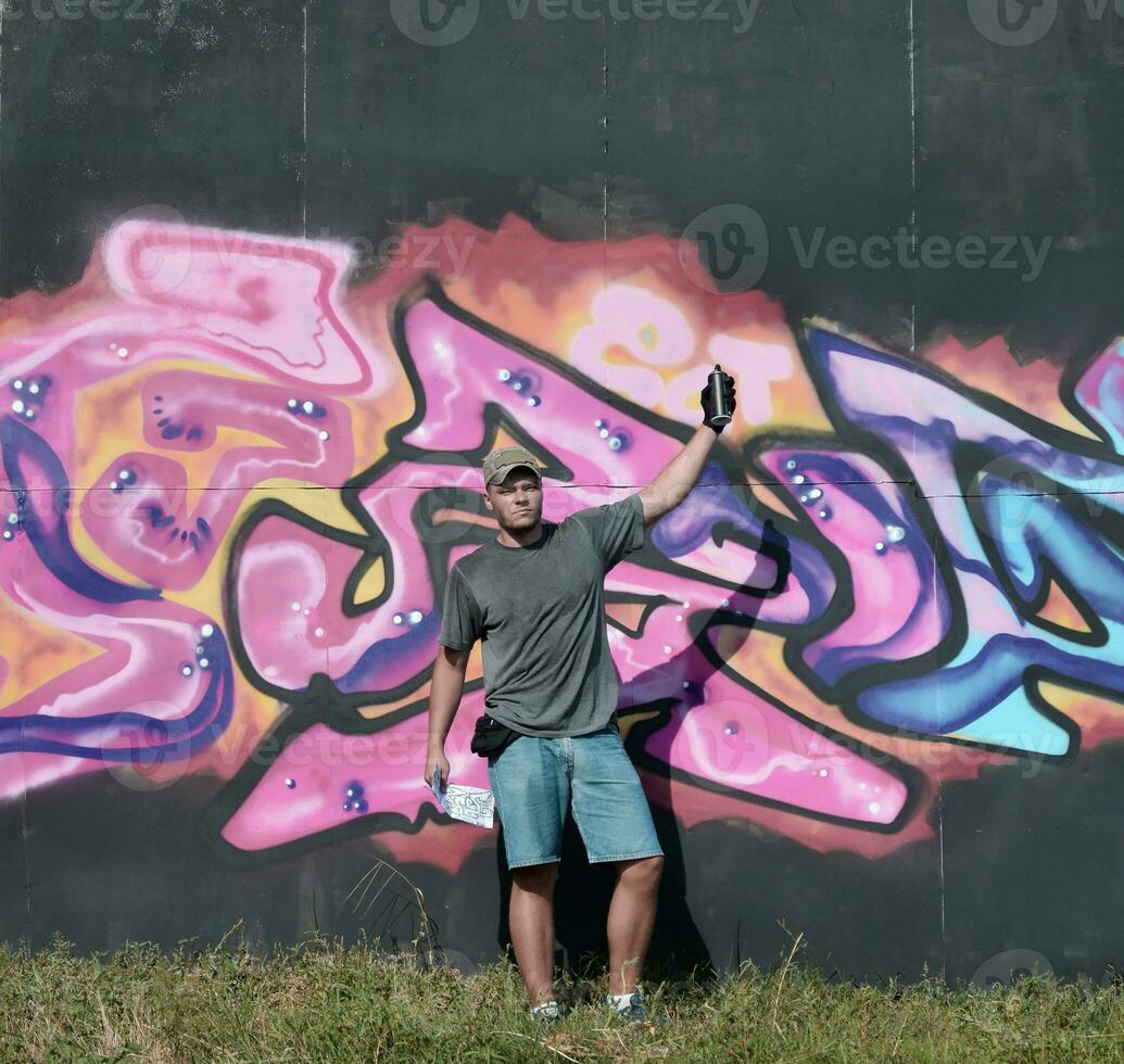 joven caucásico masculino pintada artista dibujo grande calle Arte pintura en azul y rosado tonos foto