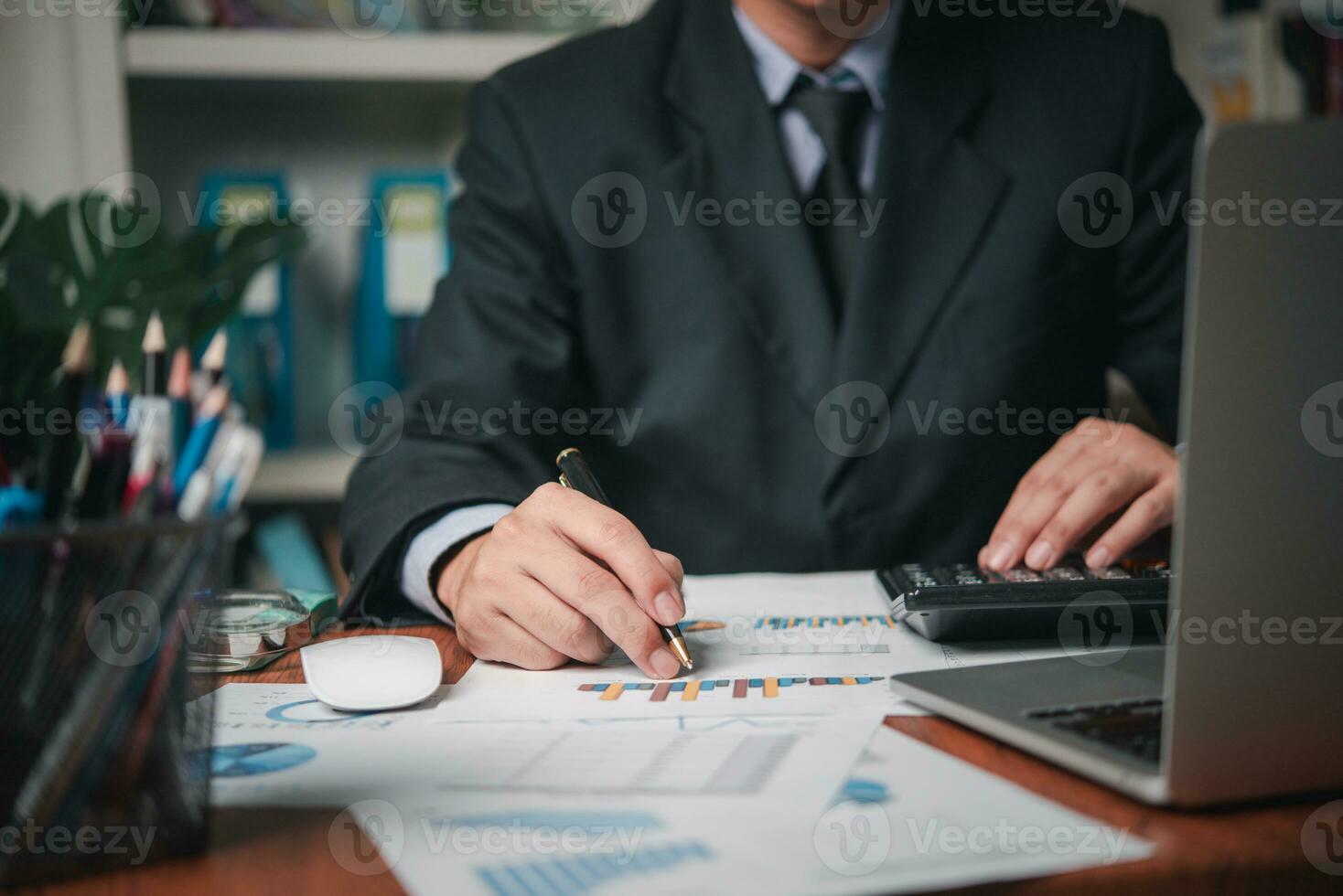 businessman working accountant document graph and chart on desk using calculator for calculate finance report in office. photo