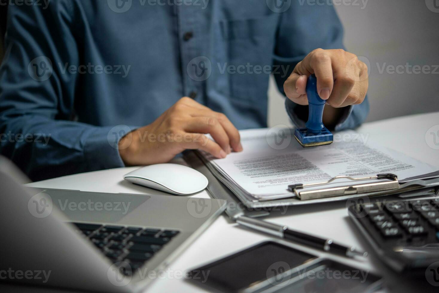 Man stamping approval of work finance banking or investment marketing documents .For official and legal contracts and agreements, financial statements, investment contracts on desk. photo