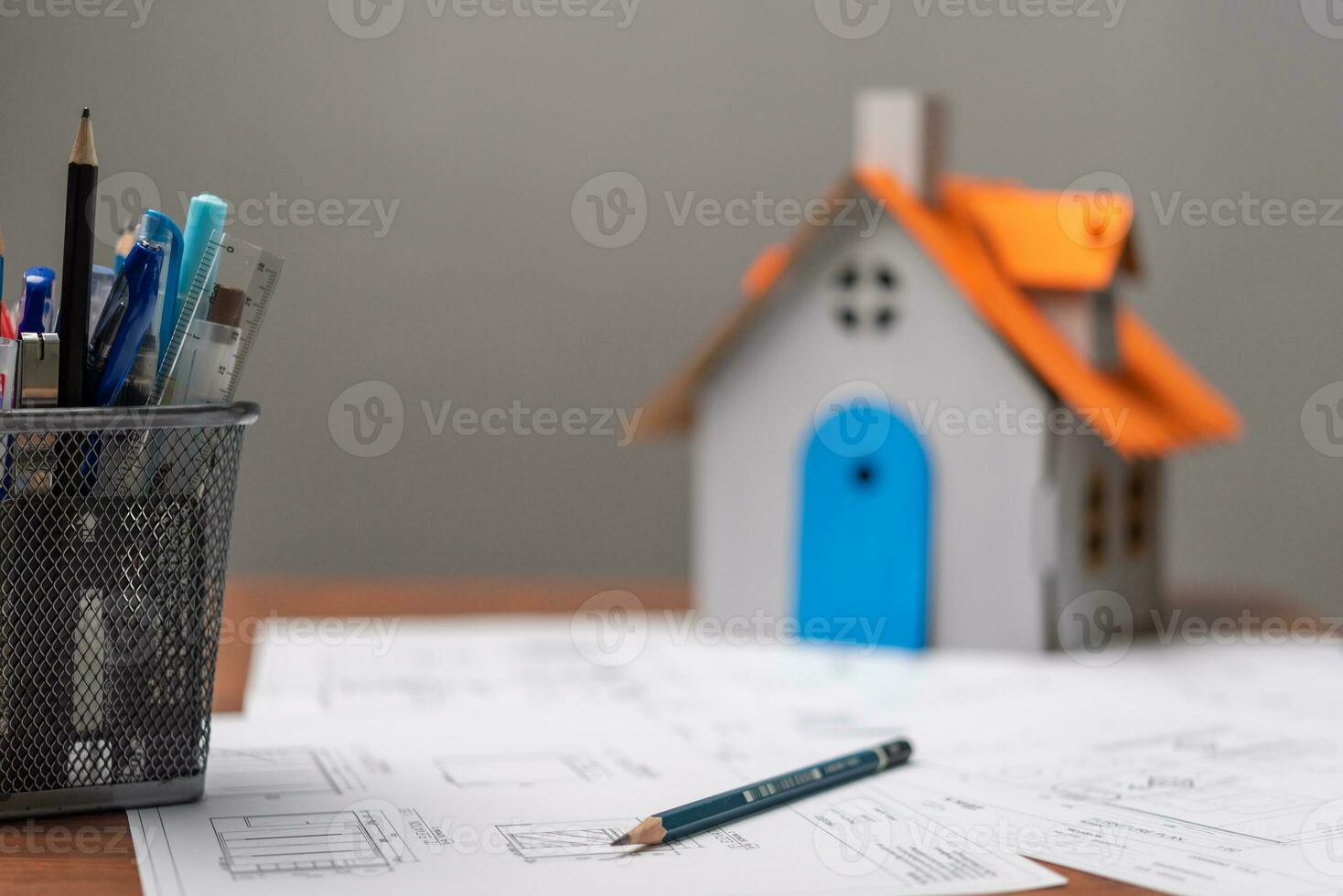 Architectural blueprints document and house model marked by measurements and construction and design details. photo