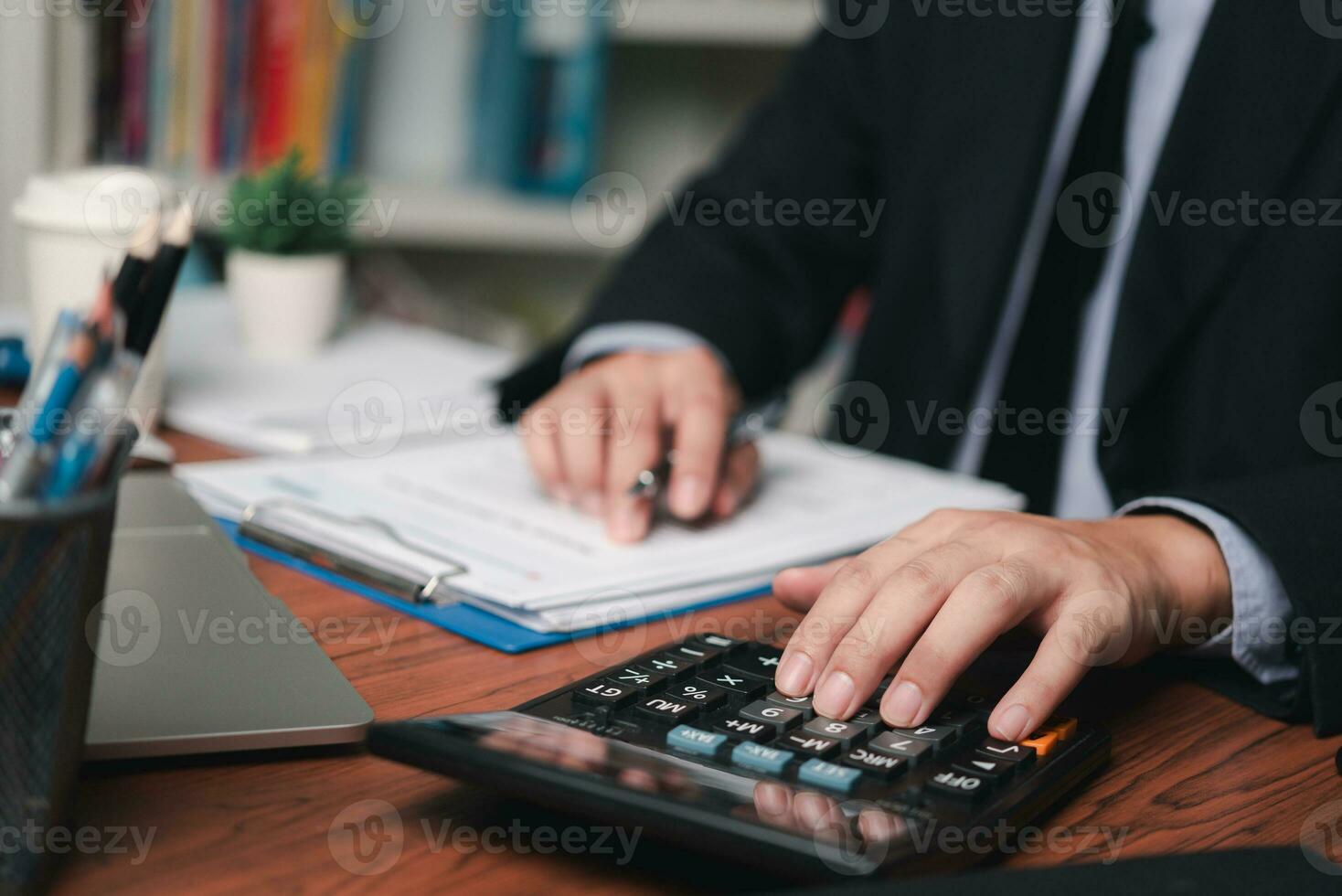 businessman working accountant document graph and chart on desk using calculator for calculate finance report in office. photo