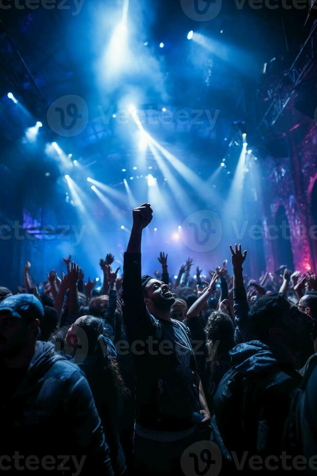 Stage lighting shining down from the top, many people holding their mobile phone flash, dancing in blue and purple. AI generative photo