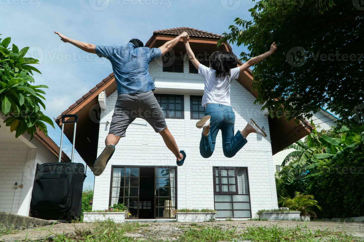 contento Pareja en frente de el nuevo hogar en Moviente en día, y comienzo un nuevo vida familia. concepto de dueño de casa y reubicación foto