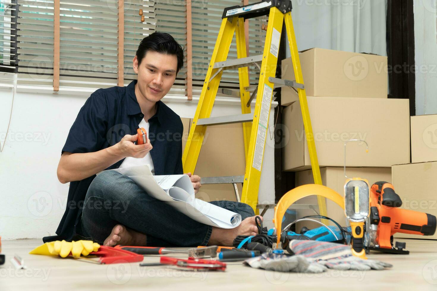 Happy Creative young Asian couple renovating house together and using a blueprint for renovation planning and how to   decorate and arrange the furniture on their new living room space photo