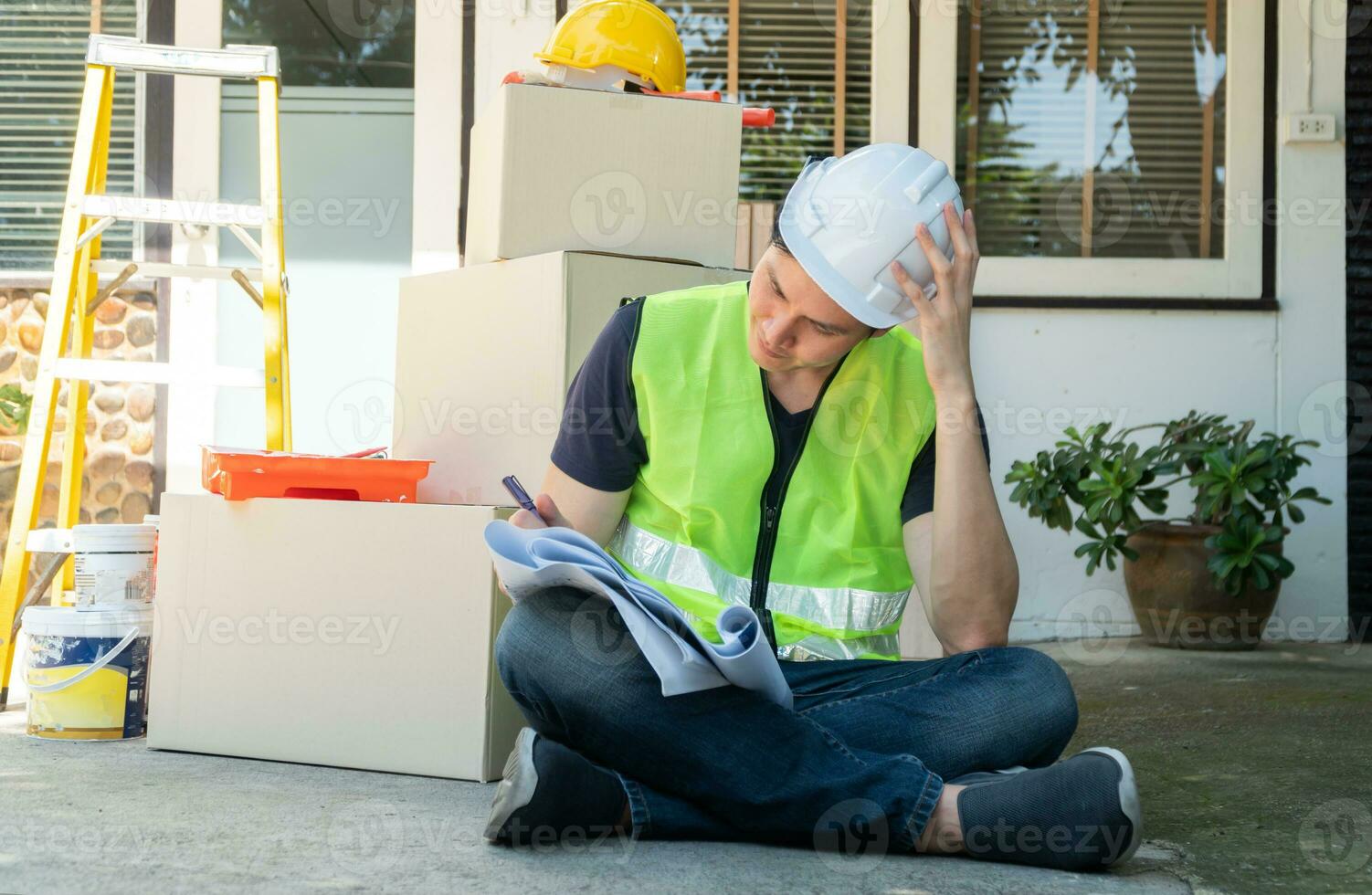 Asian homeowner holding blueprint and try to understand a plan for house renovation and design for home construction building, Concept of professional architecture and home interior and handyman photo