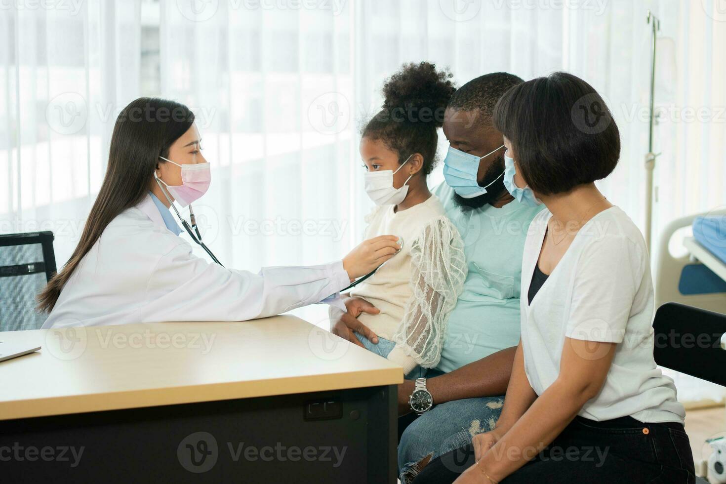 una médica pediatra asiática sostiene un estetoscopio para examinar a una niña paciente y los pulmones del corazón de un niño, un buen médico de familia que visita a un niño en casa, atención médica y medicina para el concepto de infancia. foto