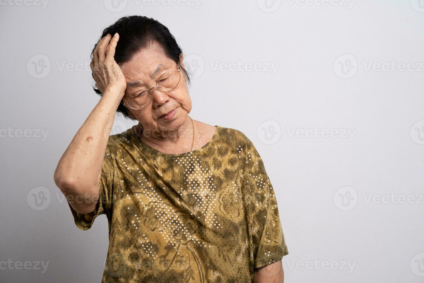 A senior woman who has a severe headache suffers from a stroke ,brain disease,patient holding head with her hand,suffering from senile dementia,memory disorders, confused old elderly with Alzheimer photo