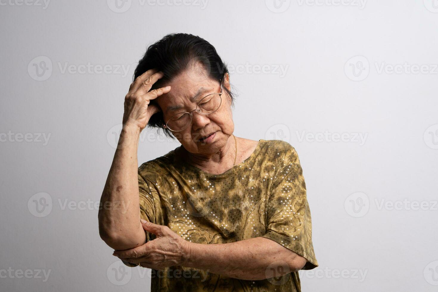 A senior woman who has a severe headache suffers from a stroke ,brain disease,patient holding head with her hand,suffering from senile dementia,memory disorders, confused old elderly with Alzheimer photo