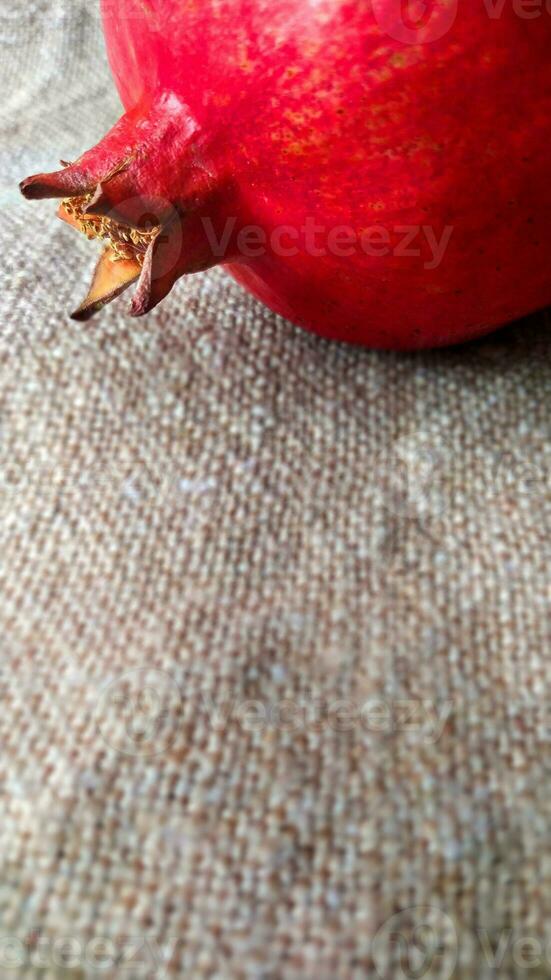 Red pomegranate fruit on canvas. Whole fruit and its grains. Square format. photo