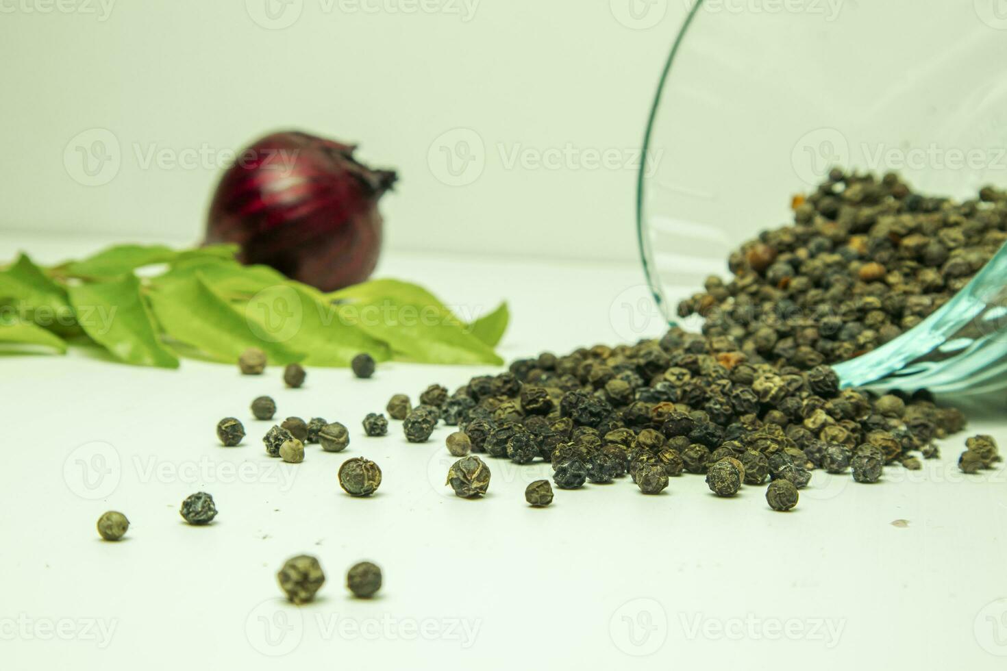 Black pepper with green tea leaves and red onion on white background. photo