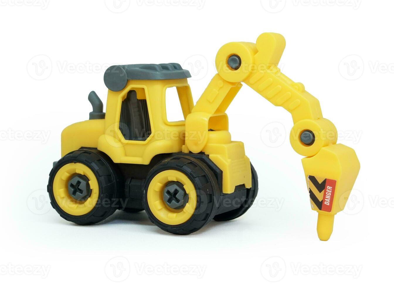 side view of yellow plastic tractor drill toy isolated on white background. heavy construction vehicle. photo