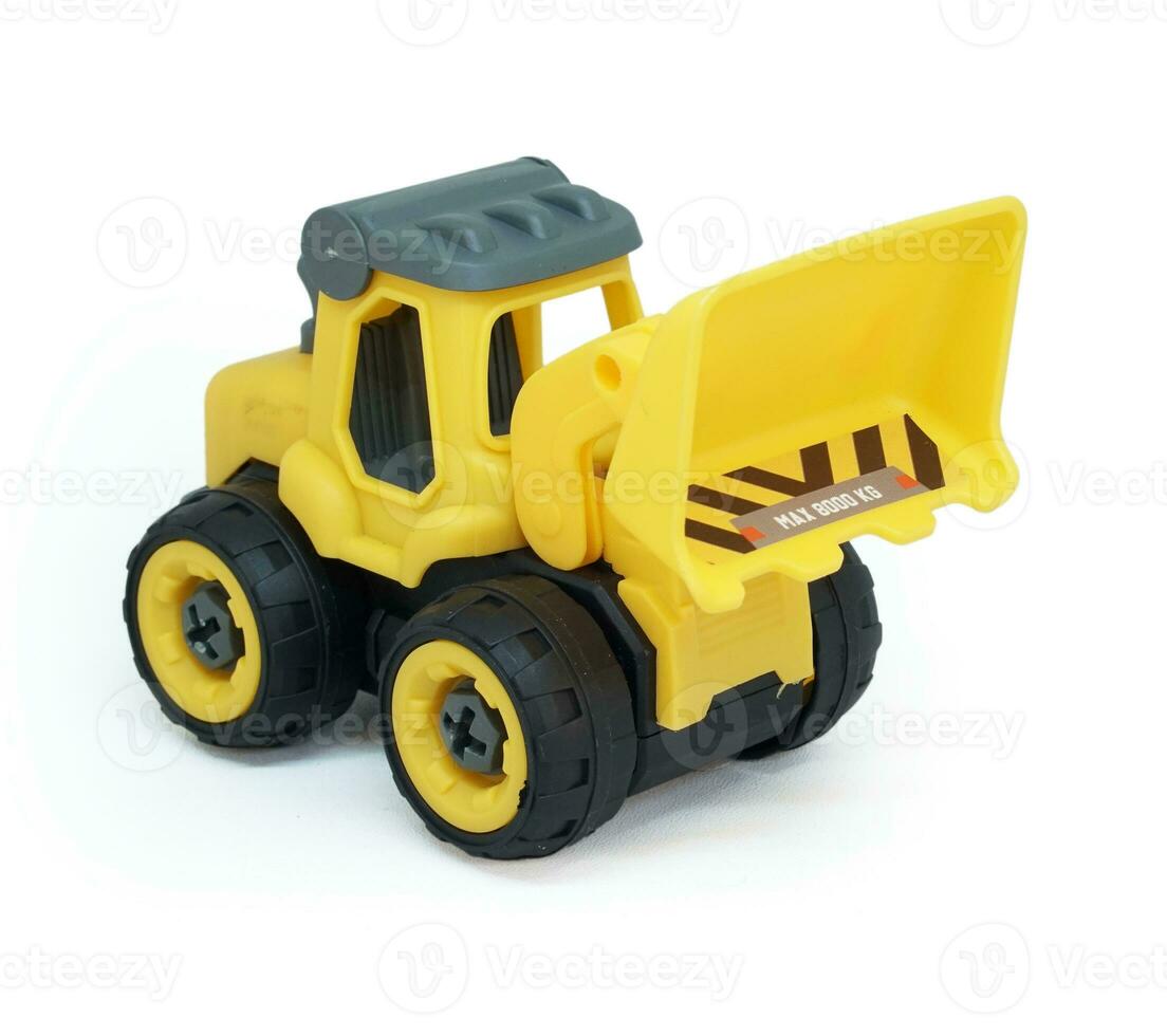 yellow plastic bulldozer toy isolated on white background. heavy construction vehicle toy. photo