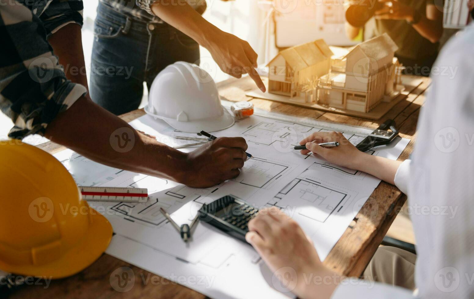 Two colleagues discussing data working and tablet, laptop with on on architectural project at construction site at desk in office photo