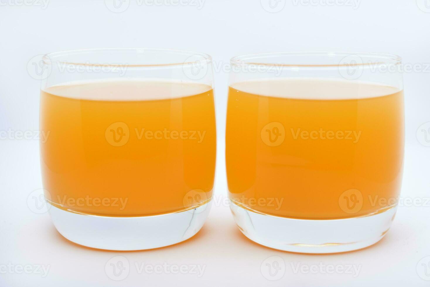 Glass glasses with orange juice on a white background. Delicious orange cooling drink. photo