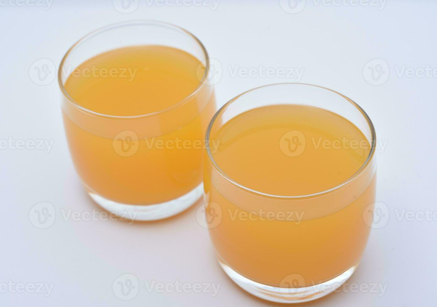Glass glasses with orange juice on a white background. Delicious orange cooling drink. photo
