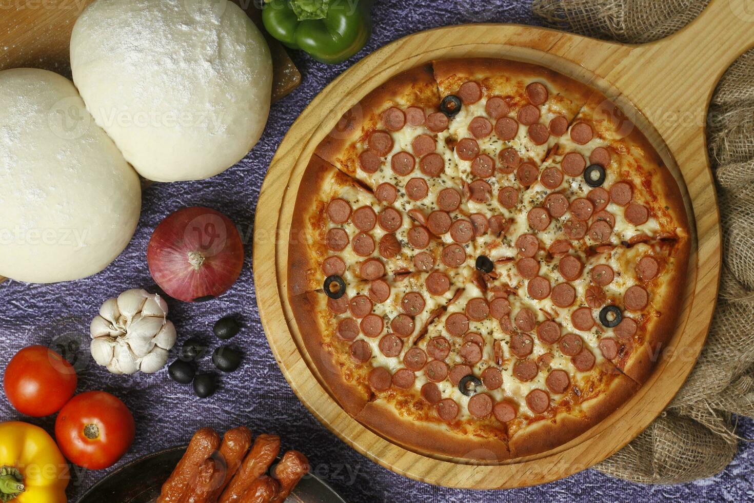 Flatbread pizza garnished with fresh angular on wooden pizza board top view dark stone background photo