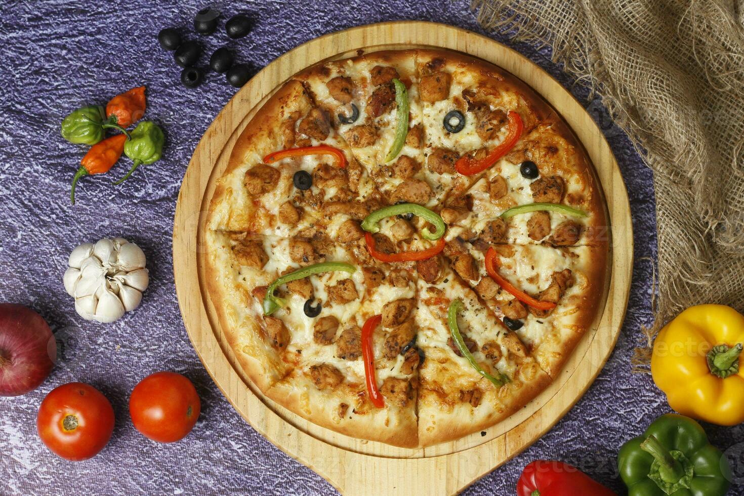 Flatbread pizza garnished with fresh angular on wooden pizza board top view dark stone background photo