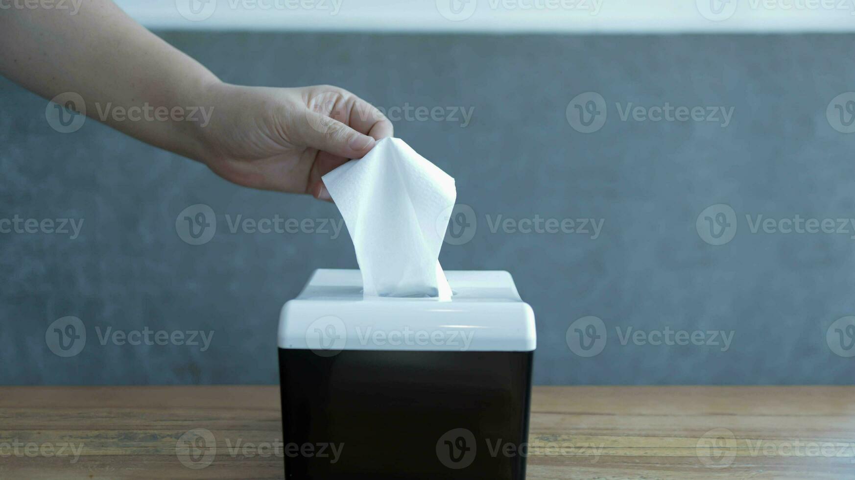 Someone pickup a tissue from a tissue box. A hand pick the tissue or holding a tissue. photo