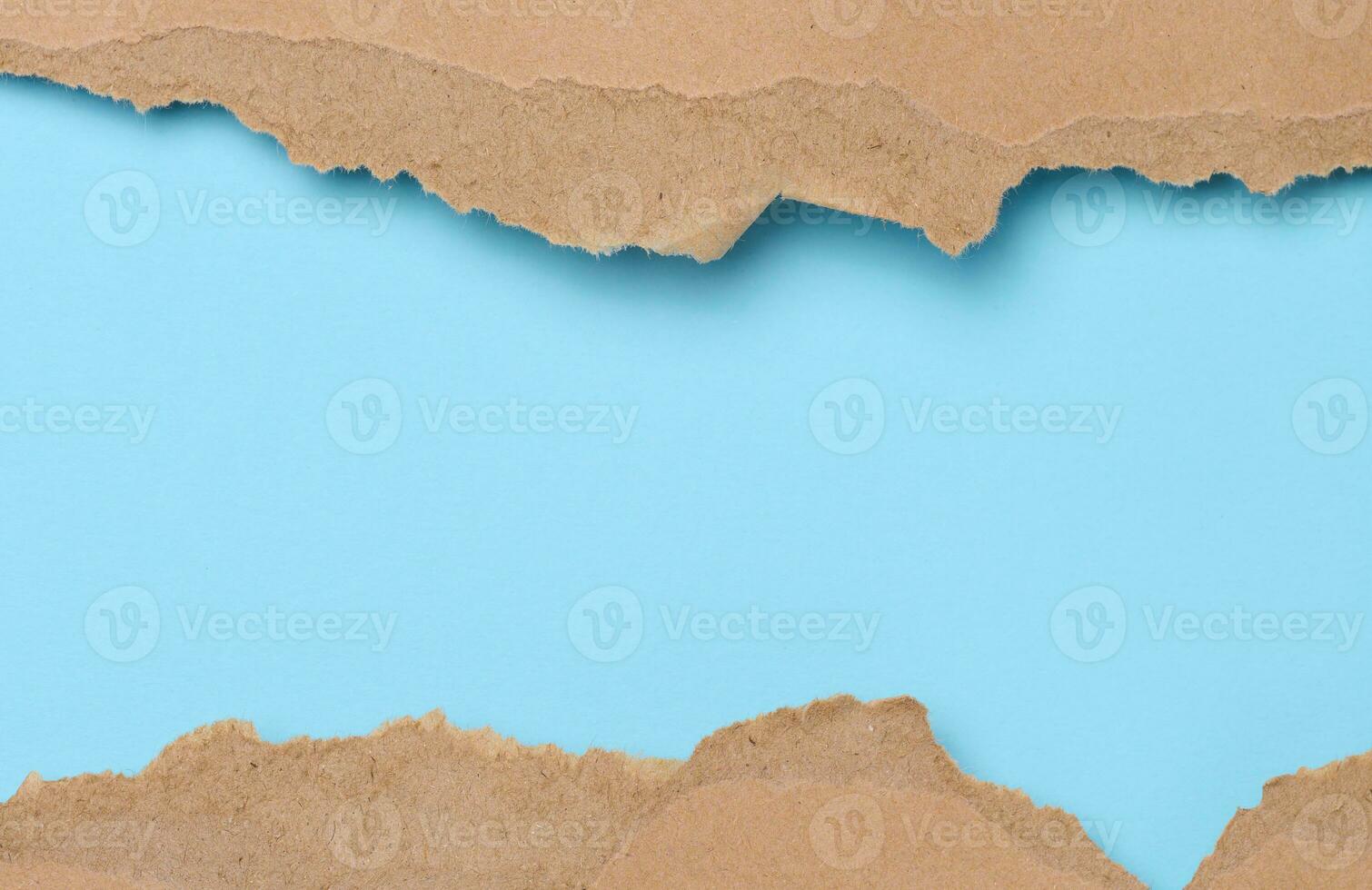 Torn edges of brown paper on a blue background, space for writing photo