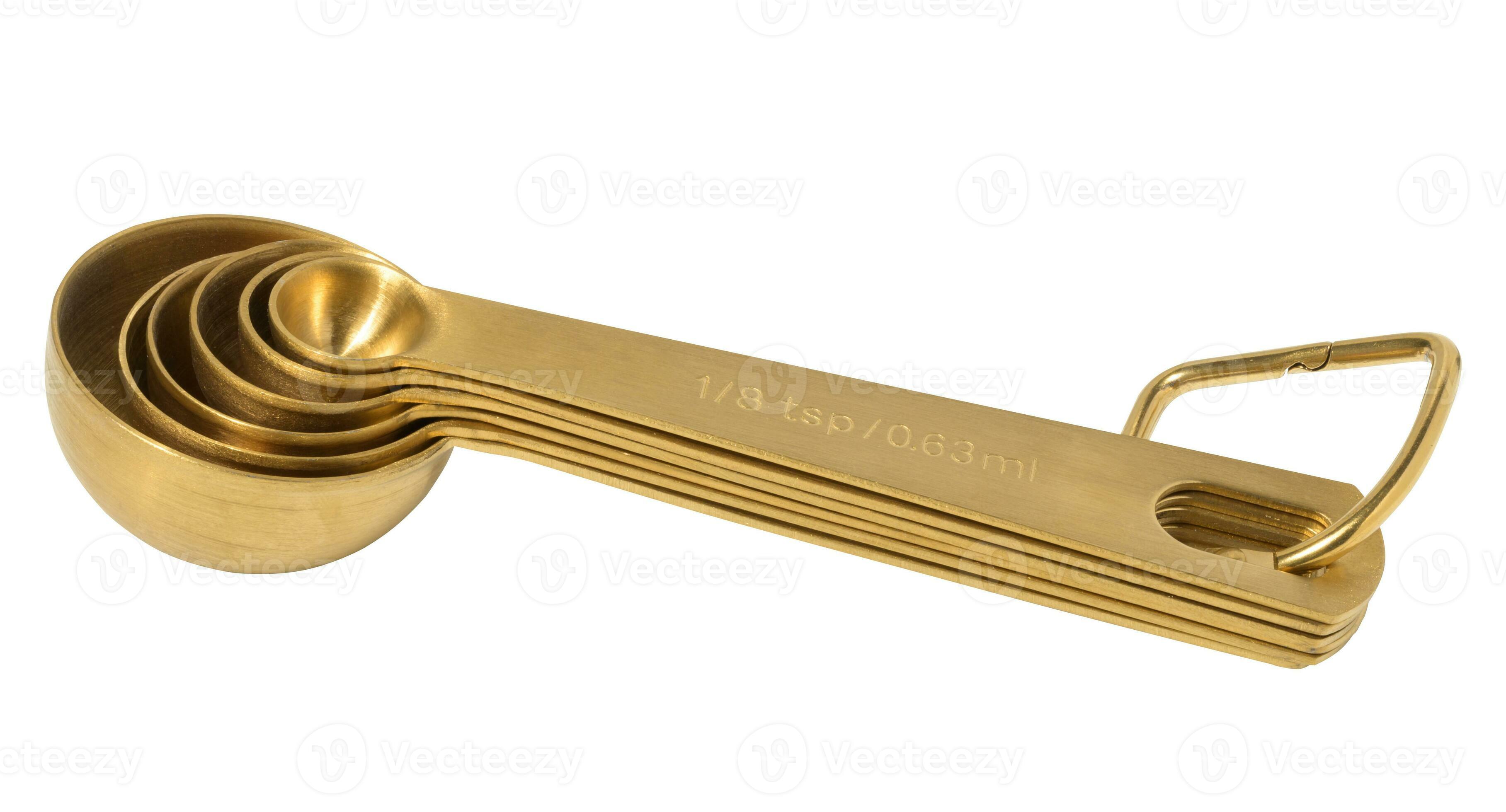 Golden metal measuring spoons for bulk and liquid products on a white