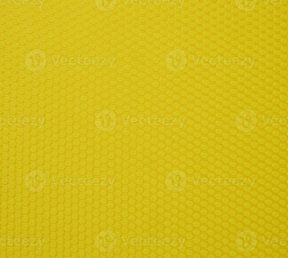 A yellow background texture made up of small hexagons that are slightly convex. photo