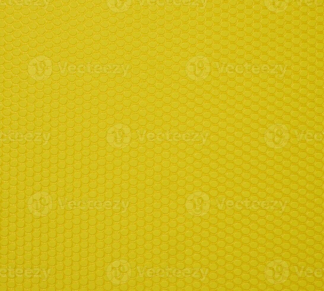 A yellow background texture made up of small hexagons that are slightly convex. photo