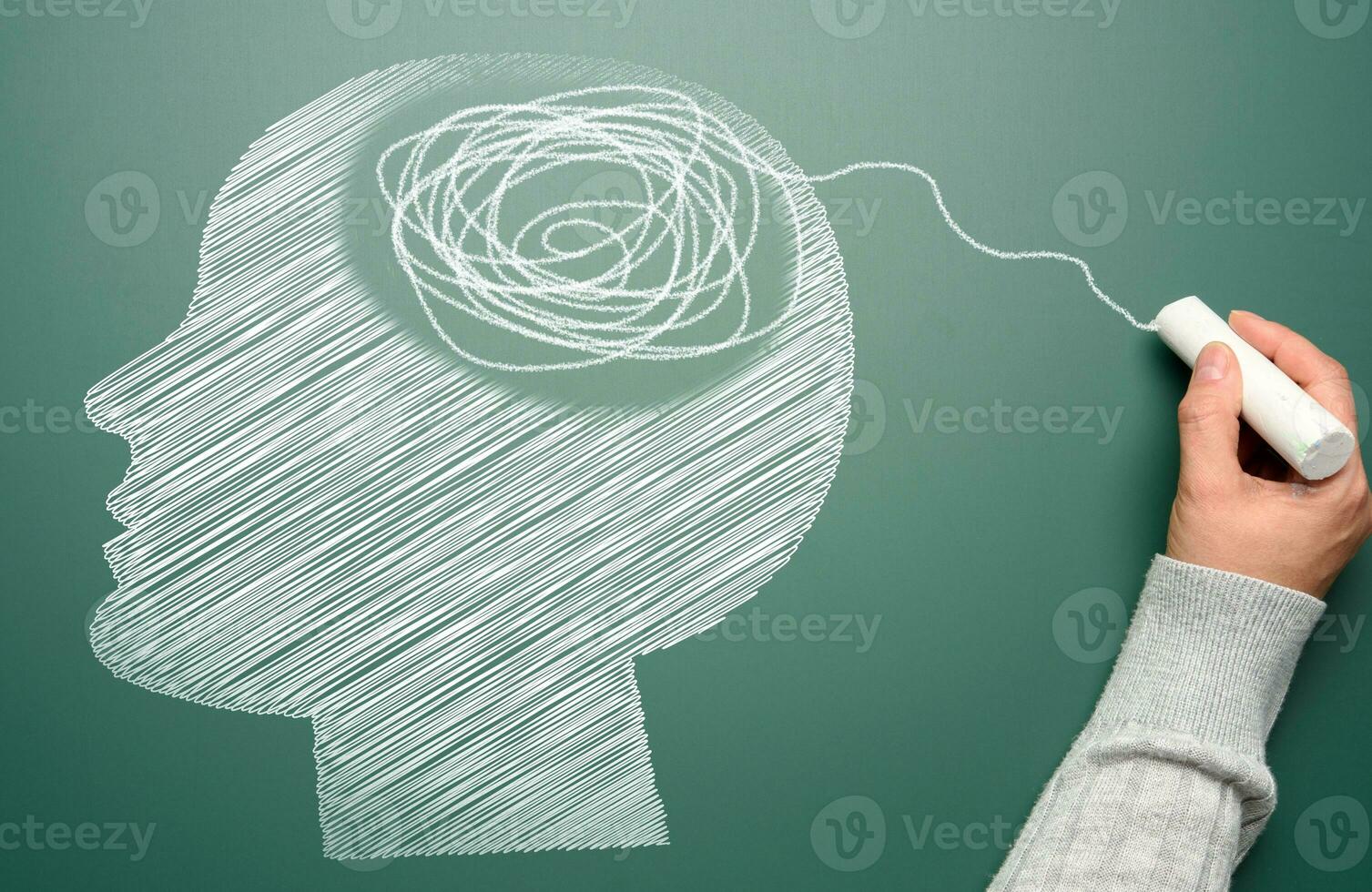 Profile of a human head with a tangled spiral in the brain area. The head is drawn in white chalk. Mental health concept photo