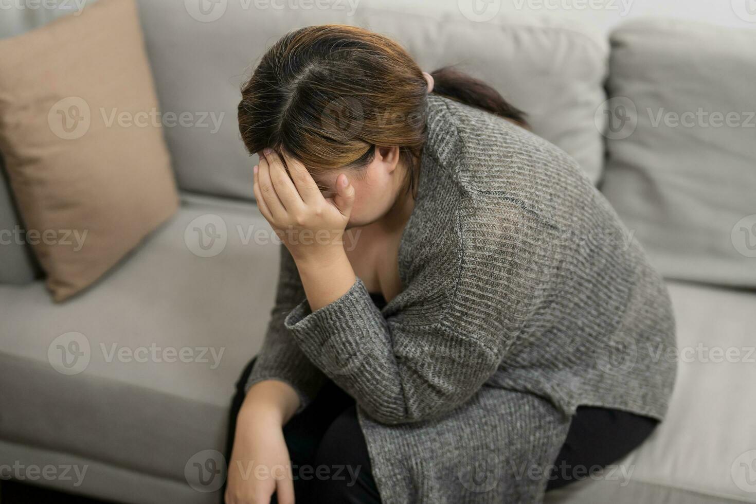 Sad Overweight plus size woman thinking about problems on sofa upset girl feeling lonely and sad from bad relationship or Depressed woman disorder mental health. photo
