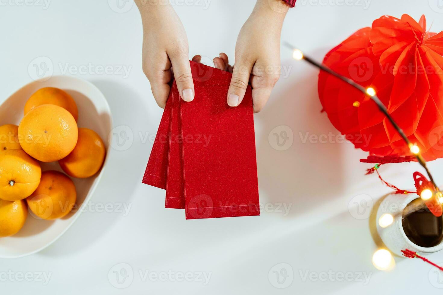 Asian Woman giving red envelope for Lunar New Year celebrations. Hand hold red packet photo