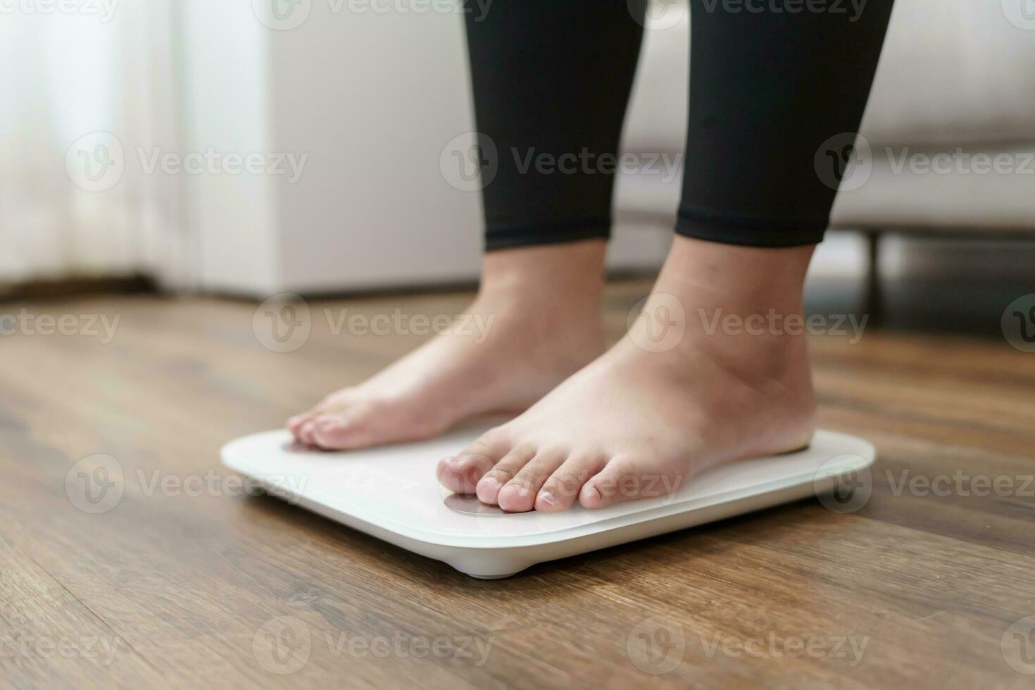 Fat diet and scale feet standing on electronic scales for weight control. Measurement instrument in kilogram for a diet control. photo