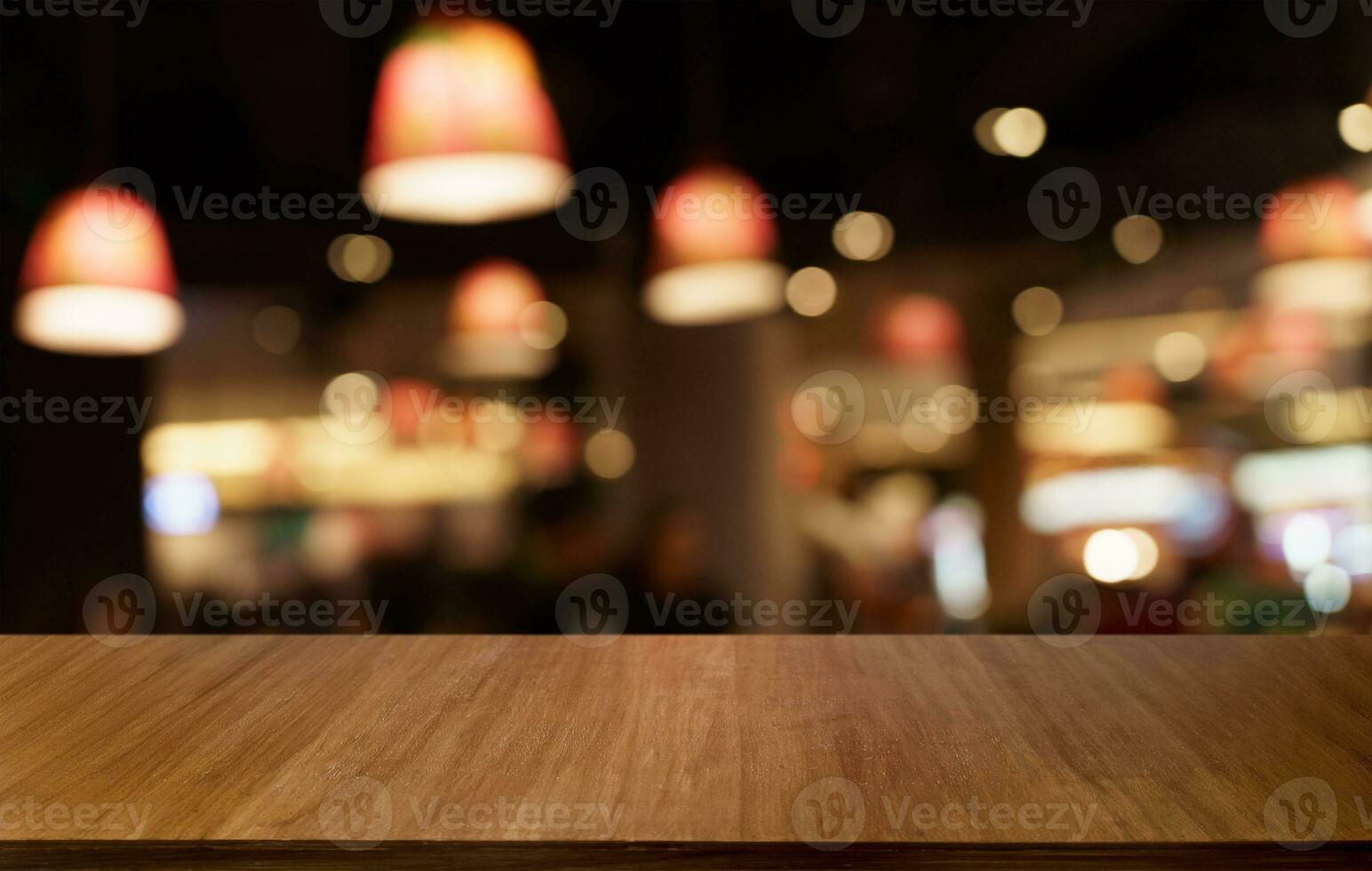 Mock up for space. Empty dark wooden table in front of abstract blurred bokeh background of restaurant . can be used for display or montage your product photo