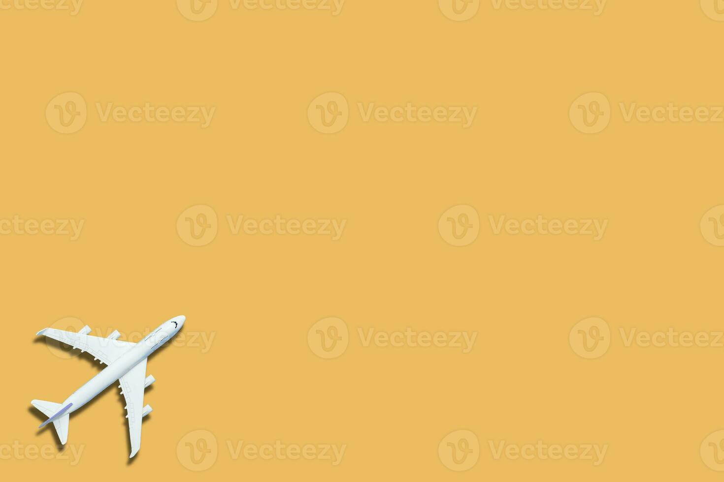 Miniature toy airplane on yellow background. Trip by airplane. photo