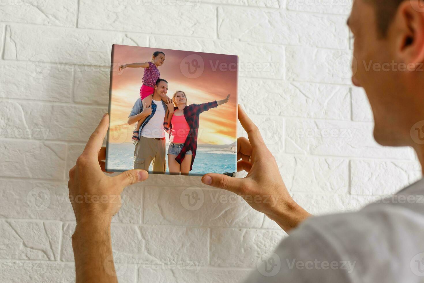 man holds photo canvas at home