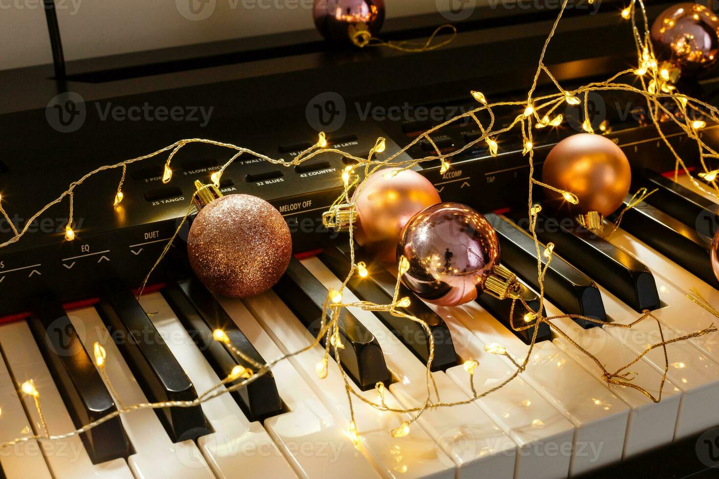 A piano with christmas lights and tree photo