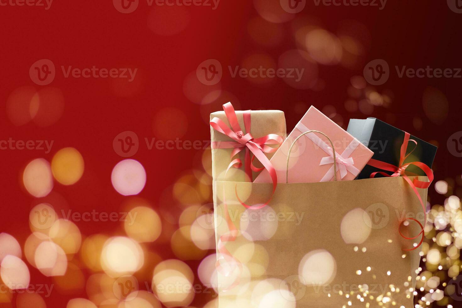 Holiday shopping bags and gift boxes on dark background, light bokeh photo