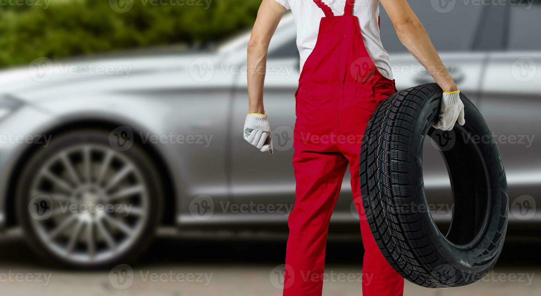 Mechanic holding a tire tire at the repair garage. replacement of winter and summer tires. photo