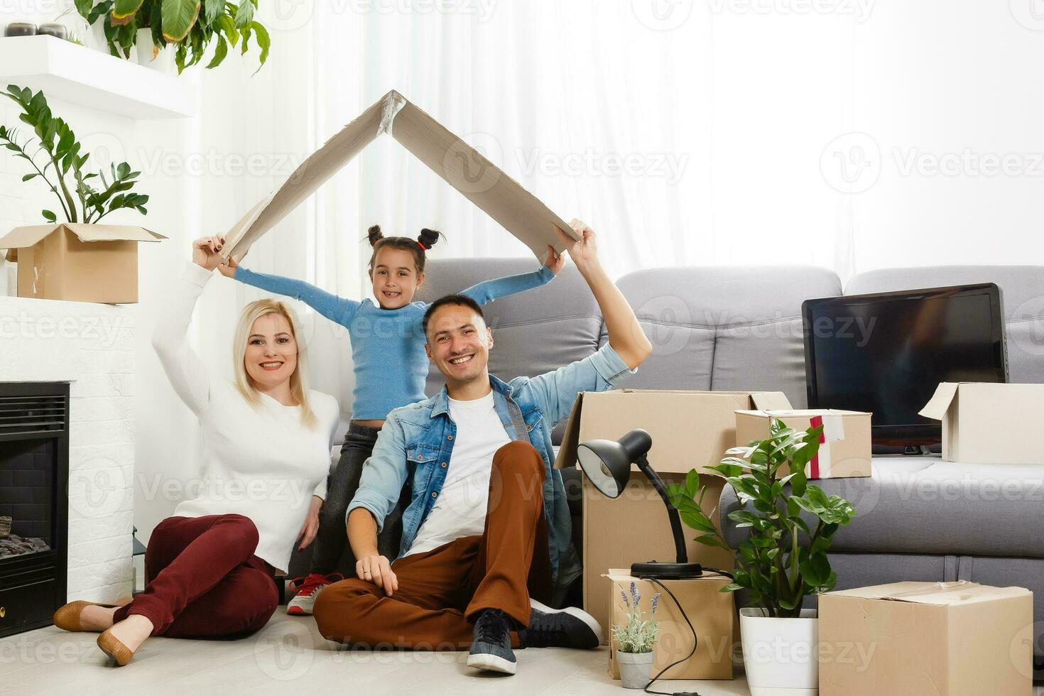 Happy family sitting on wooden floor. Father, mother and child having fun together. Moving house day, new home and design interior concept photo