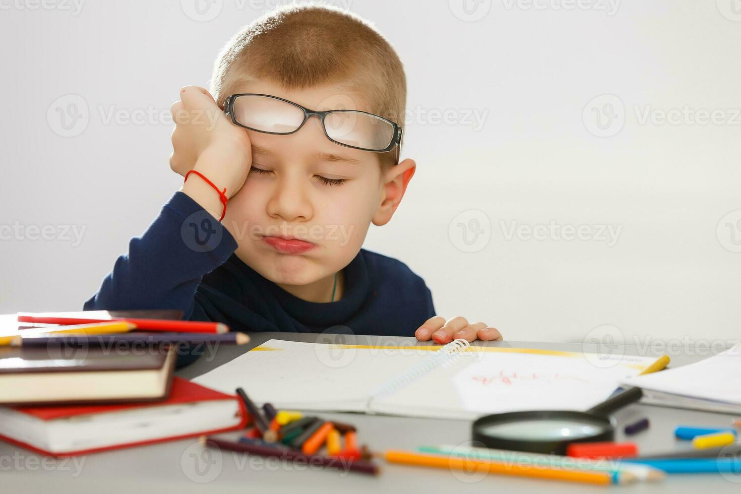 This boy is very tired of doing his homework, he fell asleep photo
