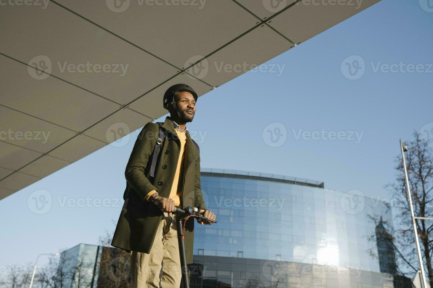 Stylish man with helmet riding a scooter in the city photo