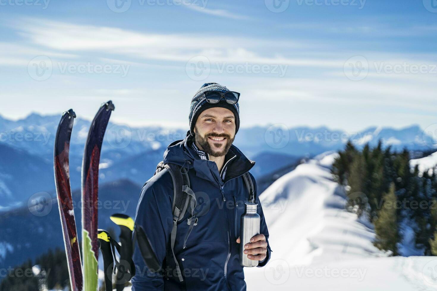 Germany, Bavaria, Brauneck, portrait of smiling man on a ski tour in winter in the mountains having a break photo