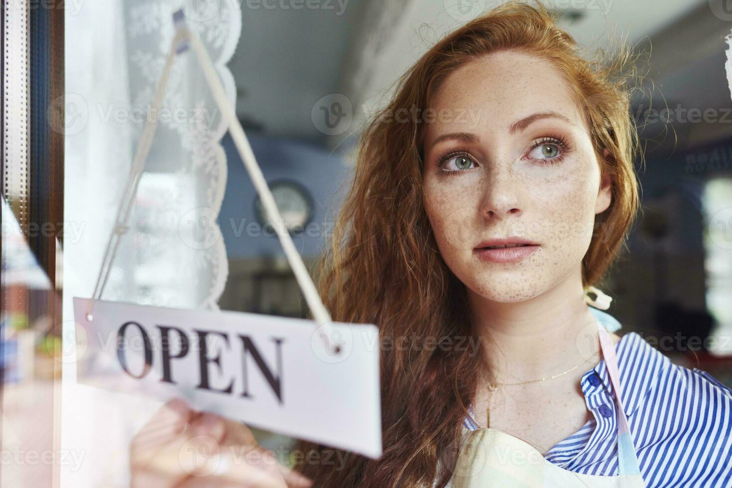 Young woman opening a shop photo