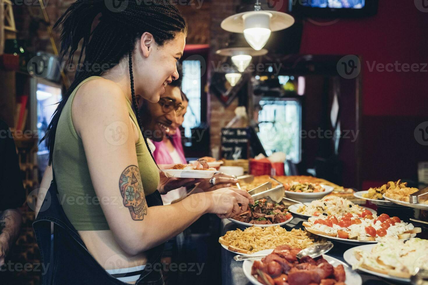 contento amigos tomando comida desde buffet en un restaurante foto
