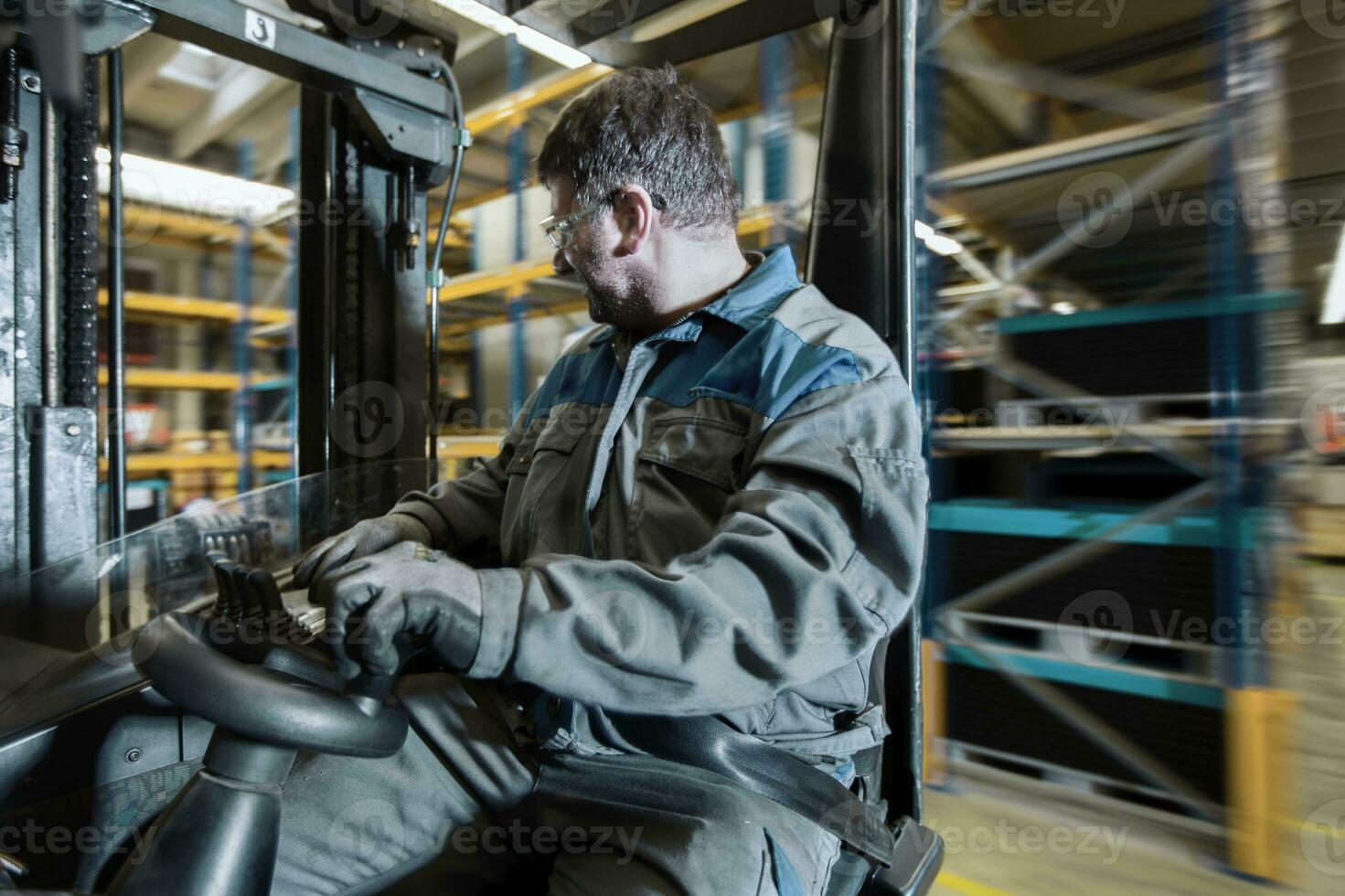 Fork-lift driver in motion in storehouse photo