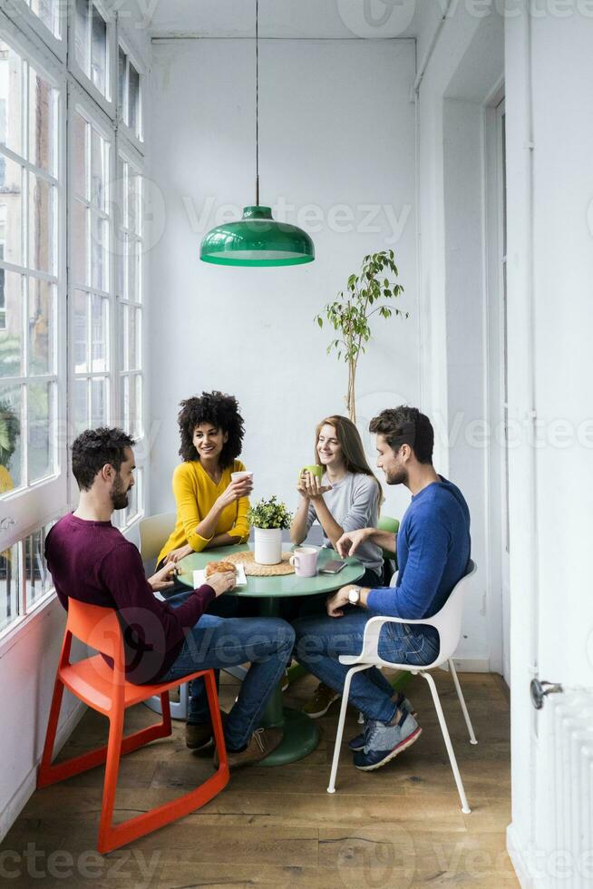 Four friends at home having coffee break photo